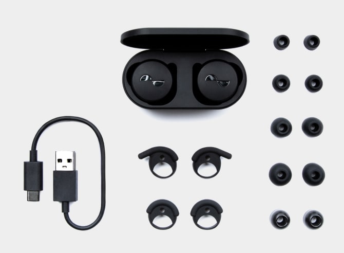 Photo of what's in the box, showing NuraTrue, charging case, USB-A to USB-C charging cable, 4 pairs multi-sized silicone ear tips, 1 pair foam tips, and 2 pairs wing attachments.